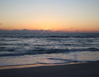 Waves and clouds seen from the shoreline at Manatee Beach at sunset