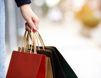 Closeup of a woman's hand holding shopping bags
