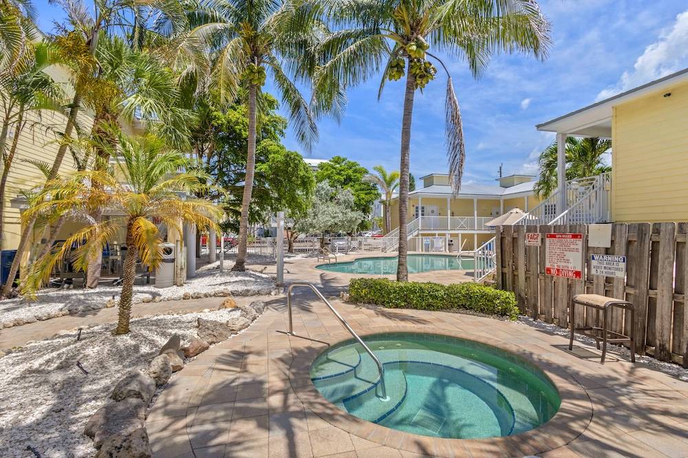 Vacation rental complex with spa and pool surrounded by palm trees