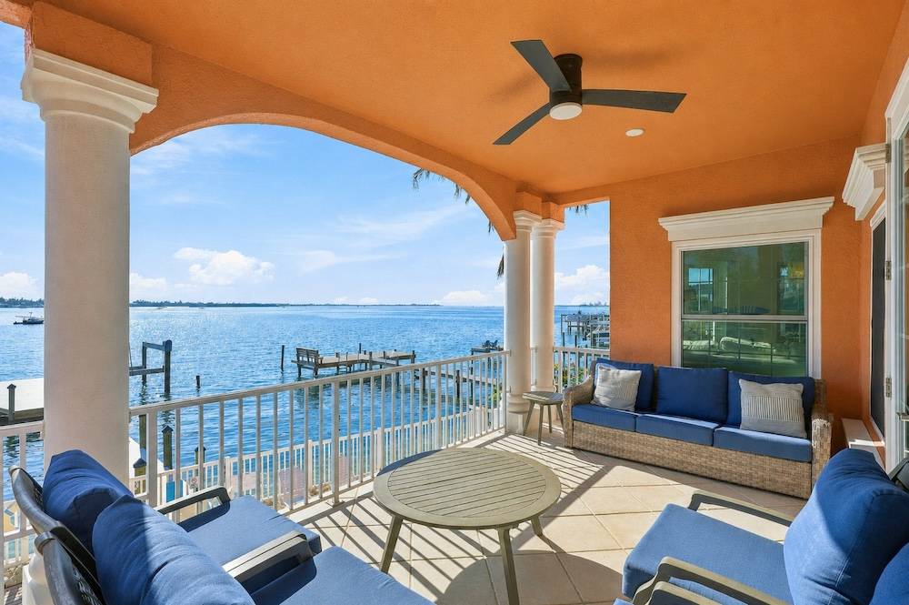Waterfront vacation rental patio with outdoor seating overlooking the bay