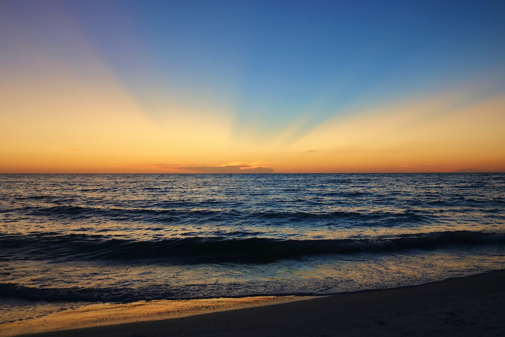 An empty shoreline and ocean at sunset