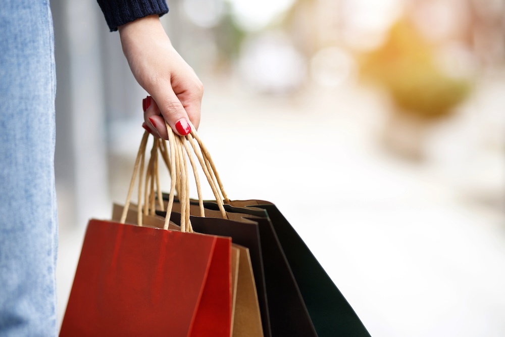 Closeup of a woman's hand holding shopping bags